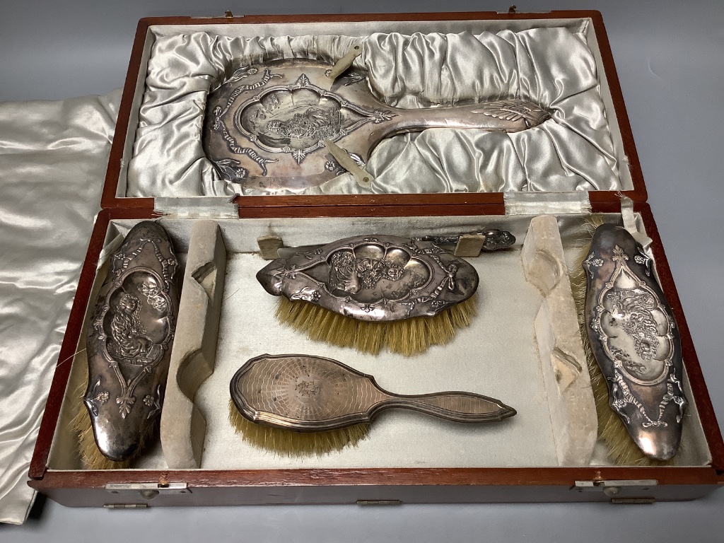 A cased George V silver four piece mirror and brush set, Birmingham, 1912, together with one other brush and a shoe horn.